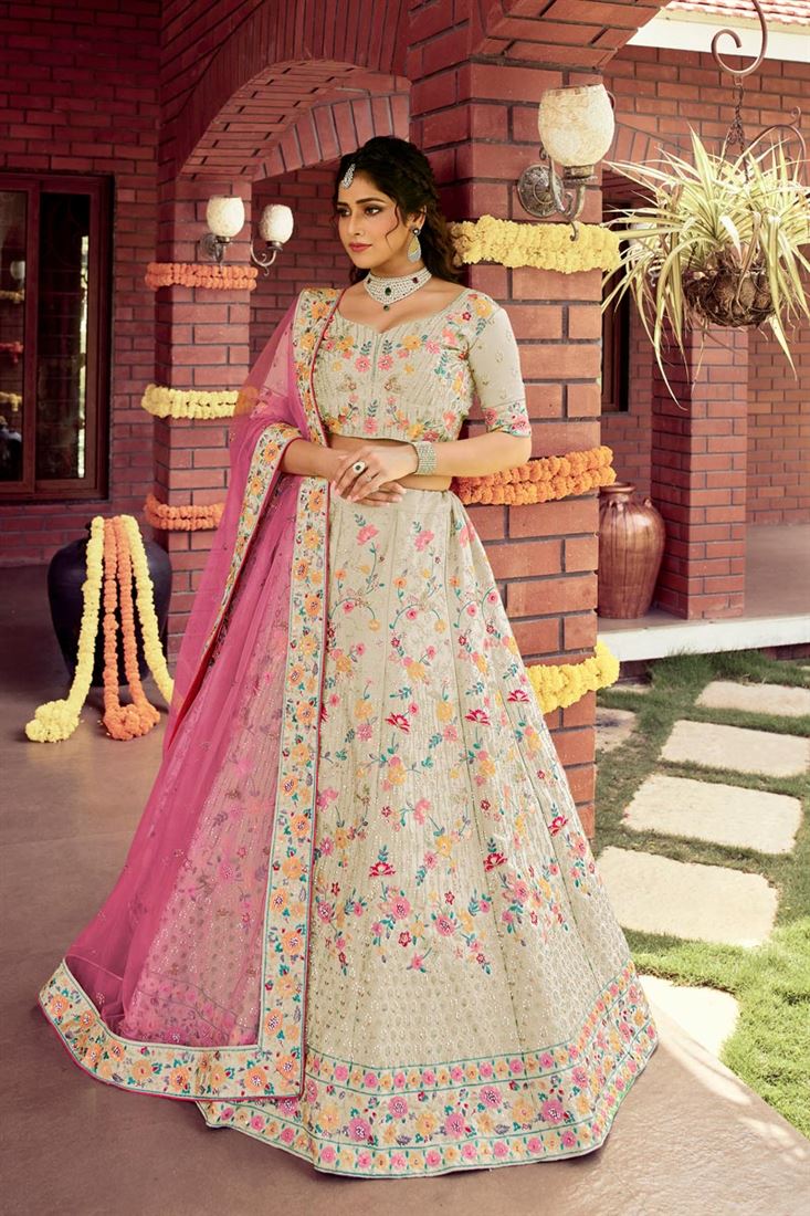 बेज रंग के आर्ट सिल्क फैब्रिक में डिज़ाइनर ब्राइडल लहंगे पर विशेष कढ़ाई का काम