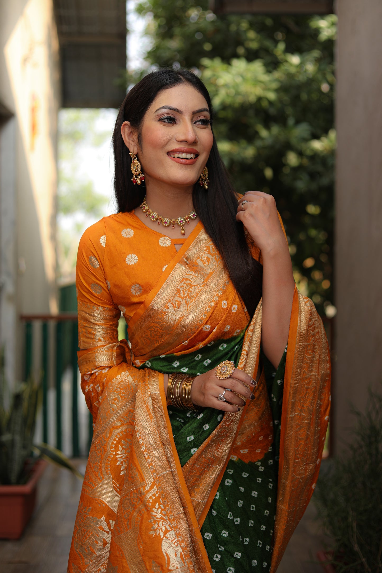 ज़री बॉर्डर रिच टिश्यू पल्लू के साथ बंधेज बॉर्डर वाली ऑरेंज वाहिनी बंधेज सिल्क साड़ी